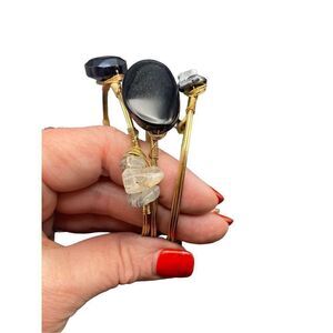 Black and gold tone wire-wrapped bangles adorned with black and white stones set